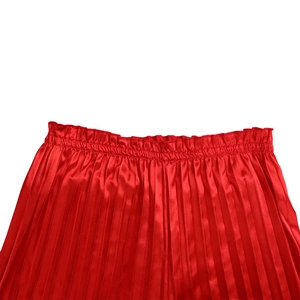 Detail of red pleated wide-leg pants featuring a high elastic waist and silky satin fabric