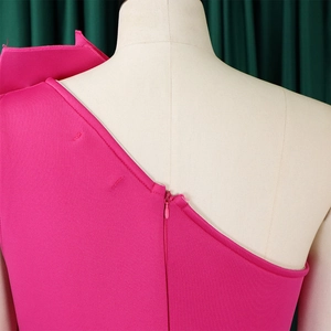 Zoom sur la fermeture éclair invisible et les coutures de la robe fuchsia à une épaule