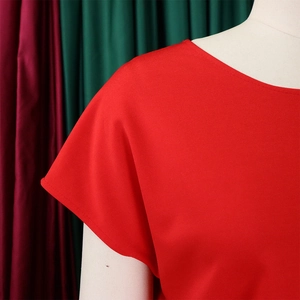 Close-up of bright red short-sleeved top showing round neckline and fine knit texture