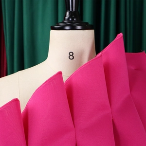 Détail du tissu fuchsia à volants et de la texture superposée d'une robe de soirée