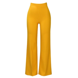 Detail view of high-waisted vibrant yellow wide-leg trousers with elastic fabric and drape