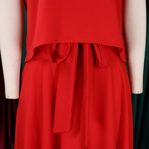 Close-up of red two-piece outfit featuring a detailed waist tie and bow design
