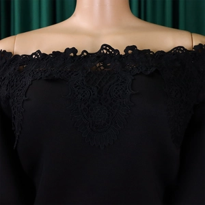 Detail of off-the-shoulder neckline featuring intricate black lace embroidery and texture