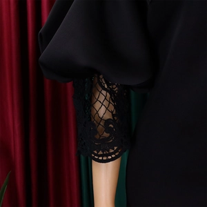 Detail of off-shoulder puff sleeves with intricate black lace embroidery and hollow-out design