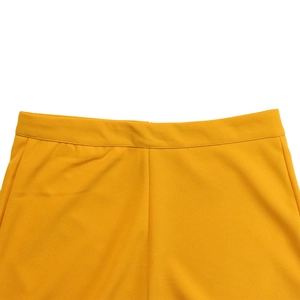 Close-up of bright yellow high waisted wide leg trousers featuring a smooth waistband design