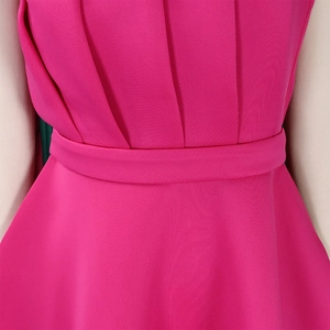 Détail de robe rose fuchsia montrant la texture plissée et la ceinture assortie