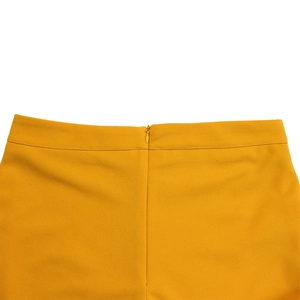 Detail of mustard yellow wide-leg trousers featuring a neat invisible back zipper