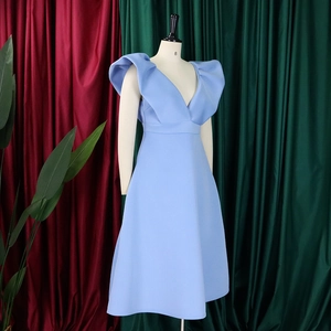 Detalle de vestido azul claro con escote en V profundo y volantes grandes en los hombros
