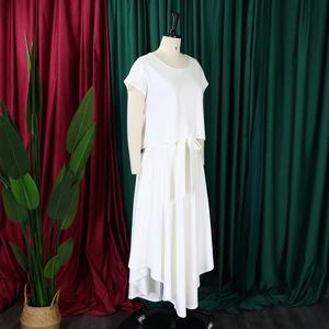 Detail of white two-piece set featuring short sleeve top and asymmetric hem skirt