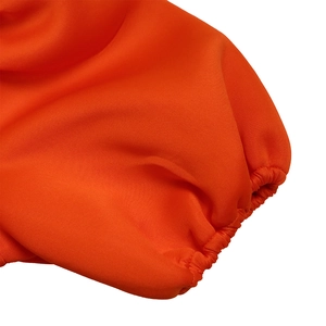 Dettaglio macro del polsino elastico arancione e della trama del tessuto a maglia