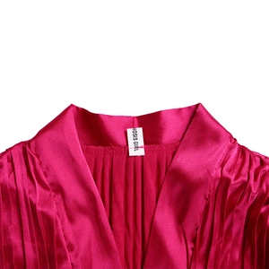 Detail eines rosaroten Satin-Hemdausschnitts mit V-Ausschnitt und feiner Faltenstruktur