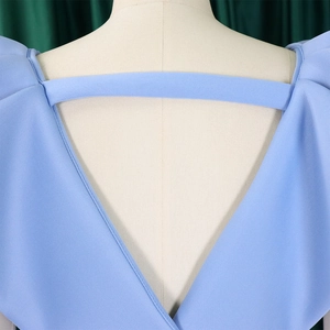 Detalle del escote en V profundo en la espalda con tira horizontal de vestido azul claro
