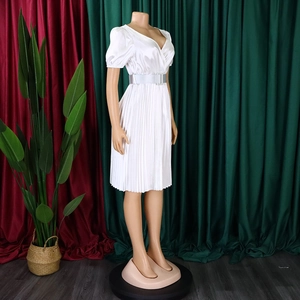 Detail of white V-neck pleated dress featuring puffed sleeves and a matching wide belt