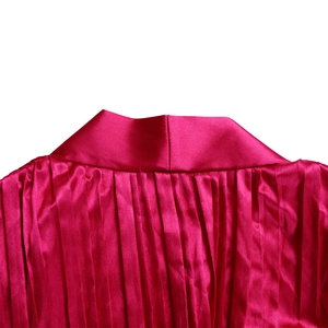 Detailaufnahme einer plissierten Satinbluse mit Stehkragen in leuchtendem Magenta