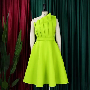Detail of lime green one-shoulder dress featuring 3D pleated bodice and cinched waistline