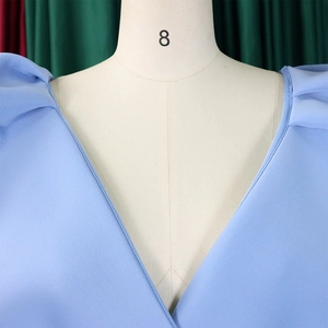 Detalle de manga abullonada azul claro y escote en V profundo en vestido formal de gala