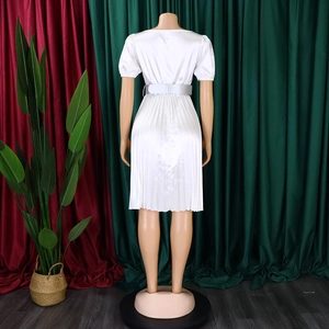 Detailed back view of a white pleated dress with a satin finish and matching belt