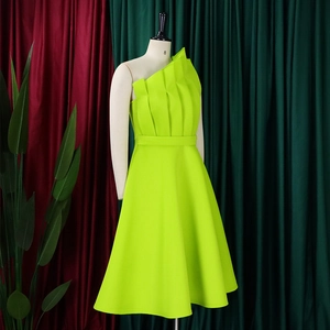 Detail view of the vertical pleated draping and asymmetric neckline on the neon green dress