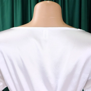 Detail of white satin dress back collar with inner label on a mannequin display