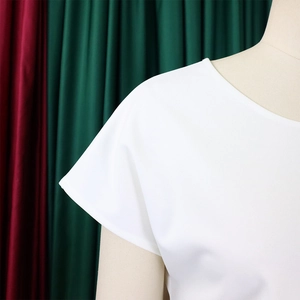 Detail of the white short-sleeve crewneck top showing smooth fabric texture on a mannequin