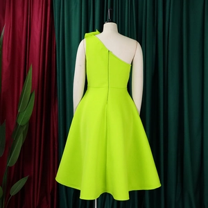Detail view of neon green one-shoulder dress showing back invisible zipper and A-line cut