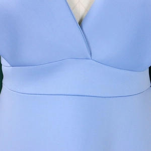 Detalle del escote en V profundo y el corte de cintura alta del vestido de gala azul claro
