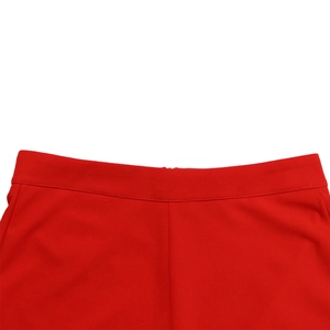 Macro shot of high-waisted red wide-leg trousers showing precise stitching and fabric texture