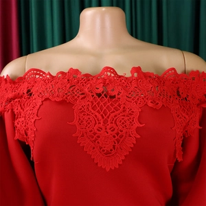 Detailed view of red off-shoulder neckline with intricate lace embroidery on the dress