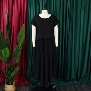Detail of black two-piece plus size set with short sleeve top and asymmetric maxi skirt