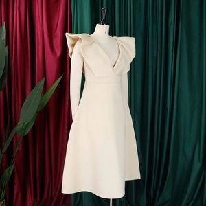 Detalle de vestido elegante con escote en V, volantes en hombros y cintura alta ceñida