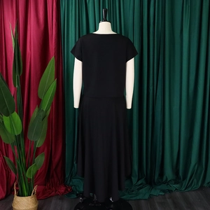 Rear view of black plus size outfit showing the asymmetric hem and flowing drape on a mannequin