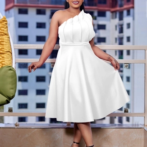 Détail de la robe blanche élégante à une épaule avec encolure volantée et taille ajustée