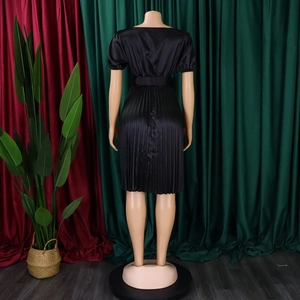 Detail of black satin pleated dress showing wide waist belt and texture from back view