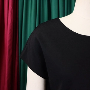 Close-up of a black crew neck short sleeve top with smooth cotton texture on a mannequin