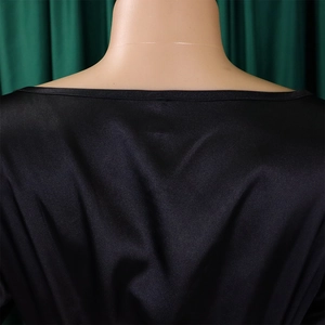Detailed view of black satin V-neck dress neckline with pleated texture and smooth finish