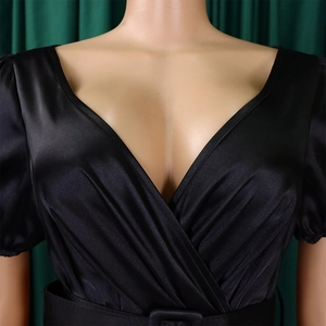 Detail of elegant black satin V-neck dress with pleated texture and stylish waist belt