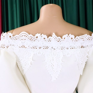 Detail view of the white off-shoulder floral lace neckline on a feminine fishtail dress