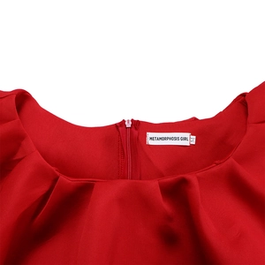 Détail d'une robe rouge élégante avec décolleté à volants et fermeture éclair invisible