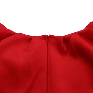 Détail de la robe de soirée rouge avec fermeture éclair invisible et encolure plissée chic