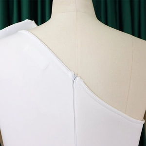 Detail of white asymmetric shoulder dress with invisible back zipper on mannequin