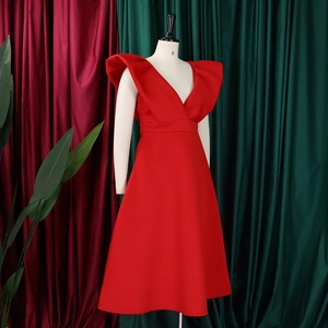 Detalle de elegante vestido rojo sin mangas con escote en V profundo y hombros con volantes