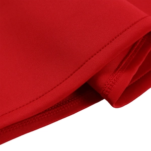 Gros plan sur un tissu en maille rouge avec une couture à double aiguille sur l'ourlet