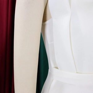 Detail of white high-waist pleated dress fabric with structured tailoring on a mannequin