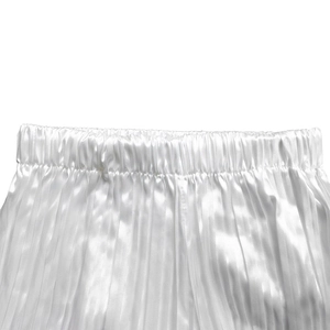 Detail der weißen Satinhose mit Plissee-Struktur und elastischem Bund für Damen