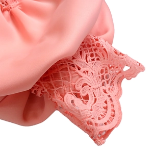 Close-up of pink silk fabric and delicate lace trim on feminine evening dress hem