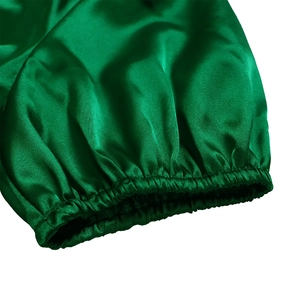Detailed macro of elastic cuff on green satin V-neck dress with silky texture