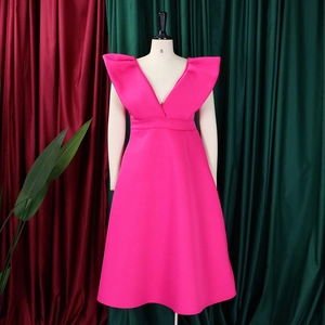 Detalle de vestido rosa con escote en V profundo, hombros con volantes y falda de línea A