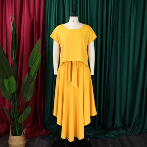 Detail of plus size bright yellow two-piece set featuring batwing sleeve top and maxi skirt