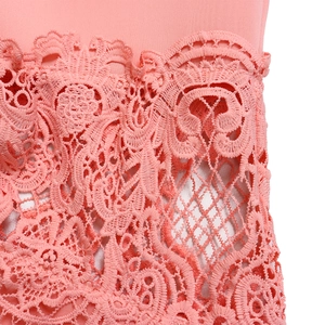 Close-up of intricate pink floral lace stitching and delicate mesh pattern on the dress