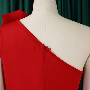 Close-up of elegant red one-shoulder dress with pleated details and hidden zipper